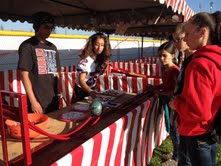 Rosalyn Hanson volunteers at the Journalism booth as kids attempt to play Roller Bowler.