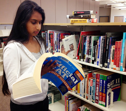 ABOVE: Sophomore Anvita Valluru tries to balance studying for her SAT exam with helping organize books at the library.