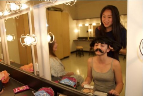 Lilla Lavanakul helps her double cast, Keiva Bradley into her Count Gregor wig as she gets ready for rehearsal.