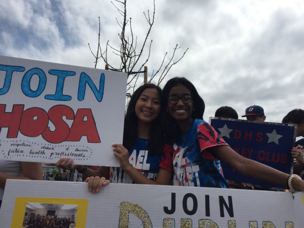 Senior Archita Padmanabhan and sophomore Abby Chiang smile with the HOSA poster at the club fair. 