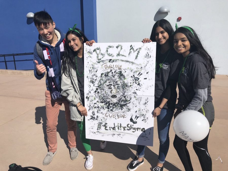 NAMI club officers pose with a sign about ending the stigma surrounding mental health.