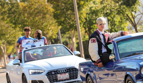 A blue Ford Mustang and white Audi convertible lead the Senior float