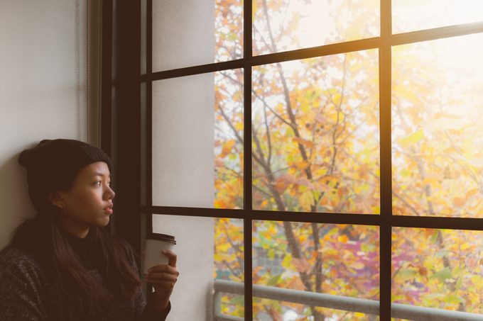 Woman looking out the window in Autumn