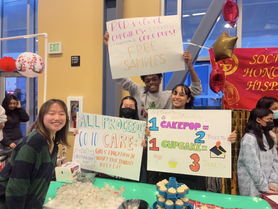 From left to right: Na Yeon Kim (11), Jillian Wong (11), Mason McGowan (10), and Belita Solanki (10); the officer board of DHS DestGrad hold up posters to advertise their booth to customers.