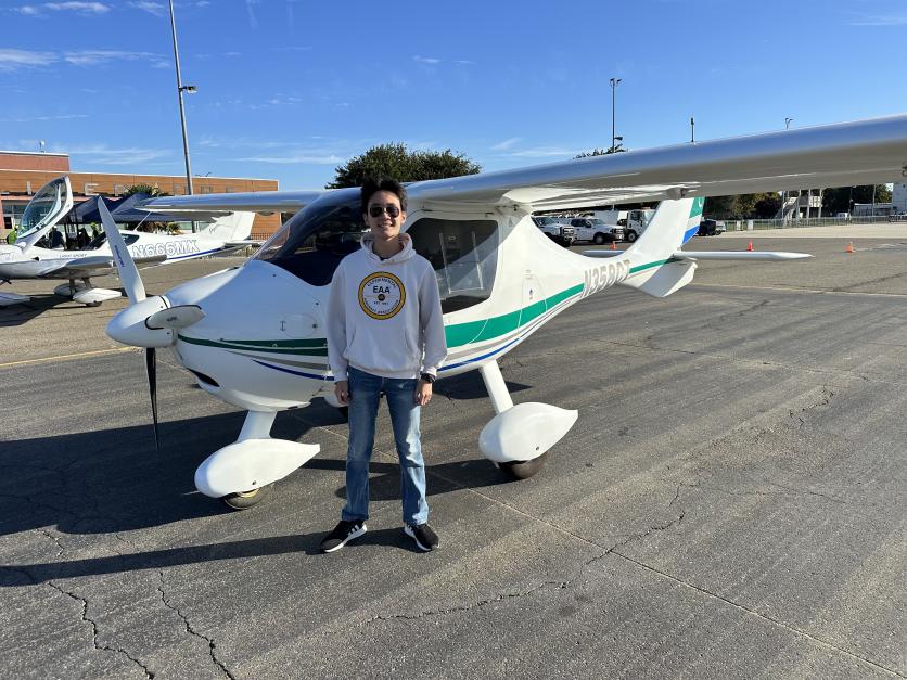 Jerry Huang standing on the tarmac with his plane Egbert
