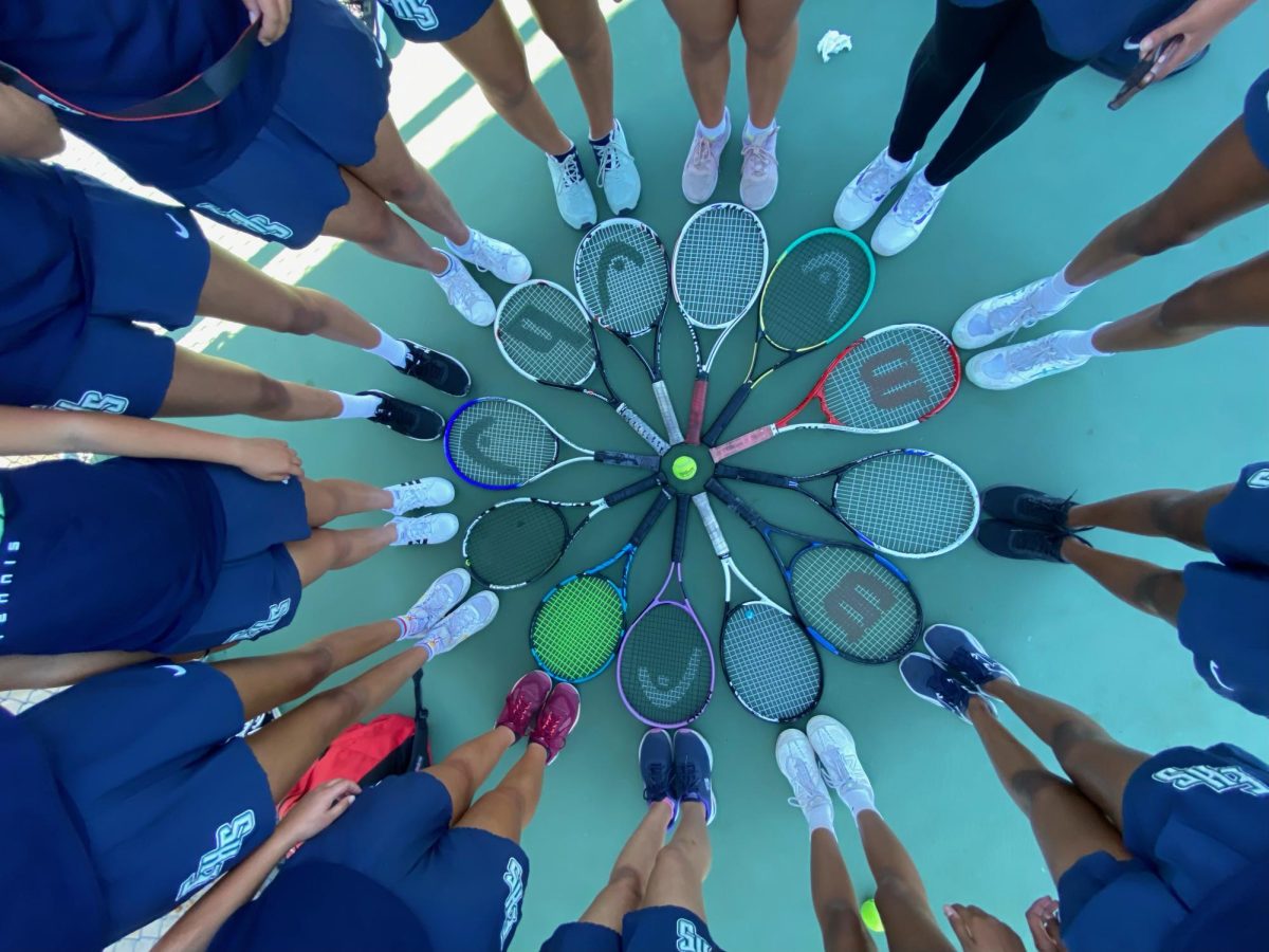 The Emerald High School Girls Tennis Team place their rackets in a circle, commemorating the end of the season. 