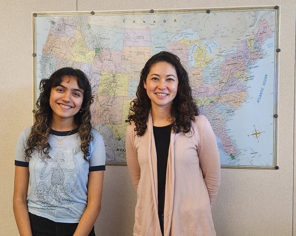 Ms. Hake, DHS history teacher, and Greeshma Adiga (11), posing in front of a map of the United States.